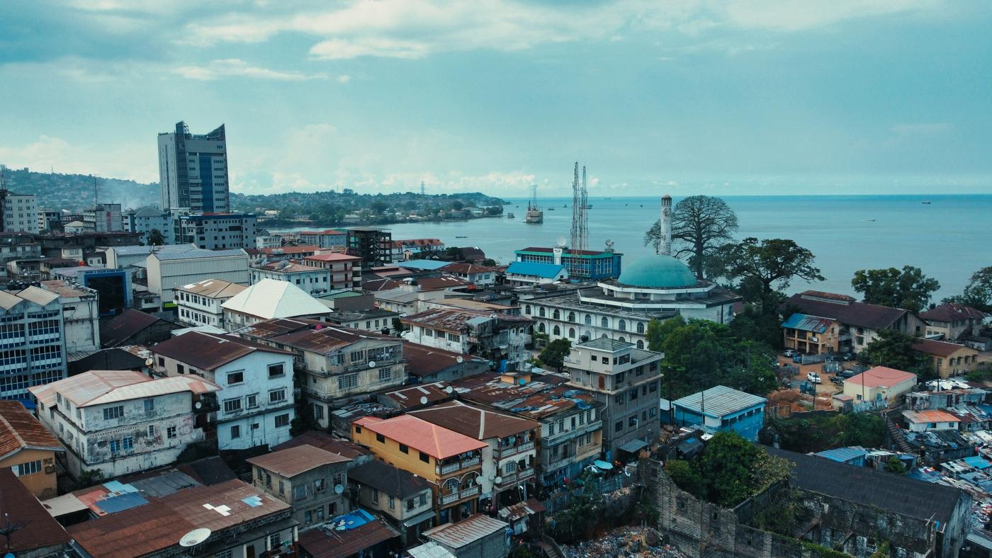 Aerial view of Freetown rooftops, a mosque and the harbour